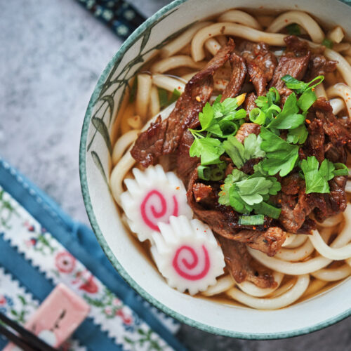 Savor the Bounties of Asia - beef udon served in a white bowl with chopsticks